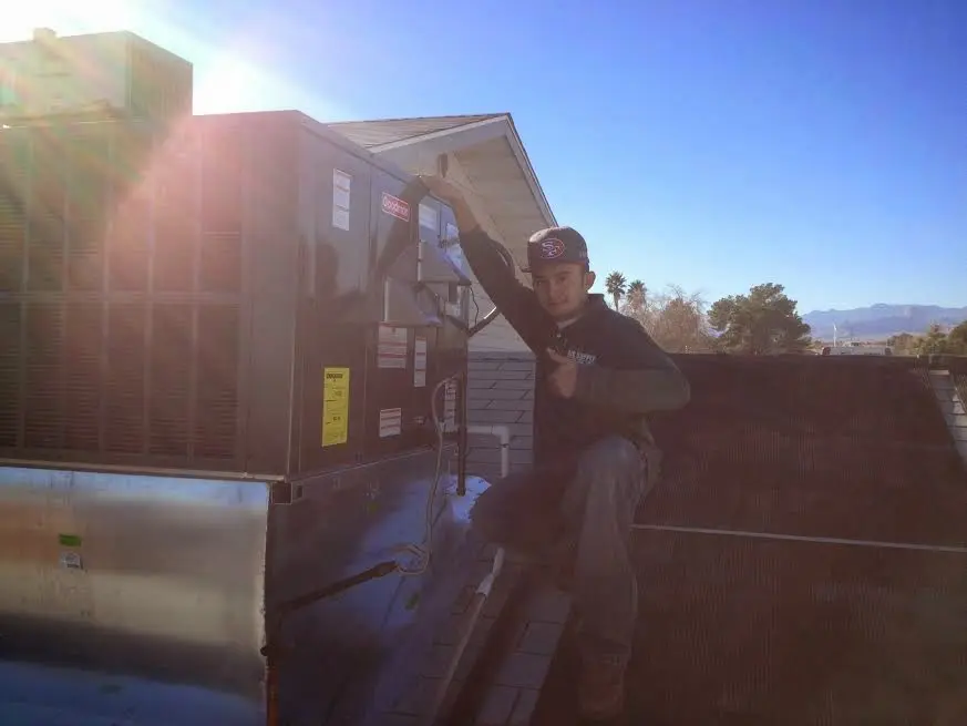 HVAC technician performing AC Tune-Up on a rooftop unit in Venersborg